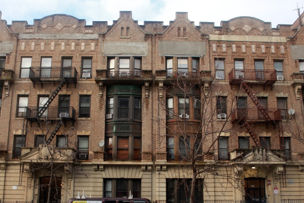 Pre-war tenement buildings sit on a Crown Heights residential block.